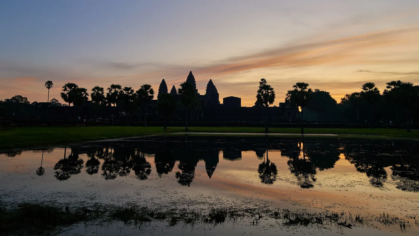 Angkor Wat's towers and their reflection in the pond at dawn