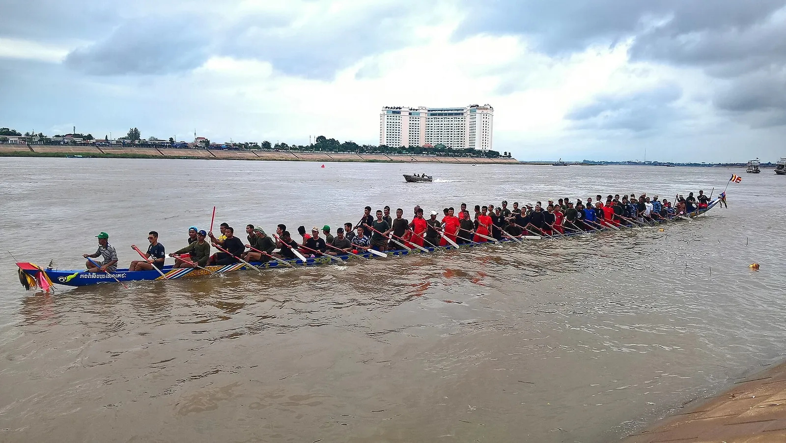Ein langes Rennboot mit Dutzenden Ruderern auf dem Fluss in Phnom Penh beim Wasserfest