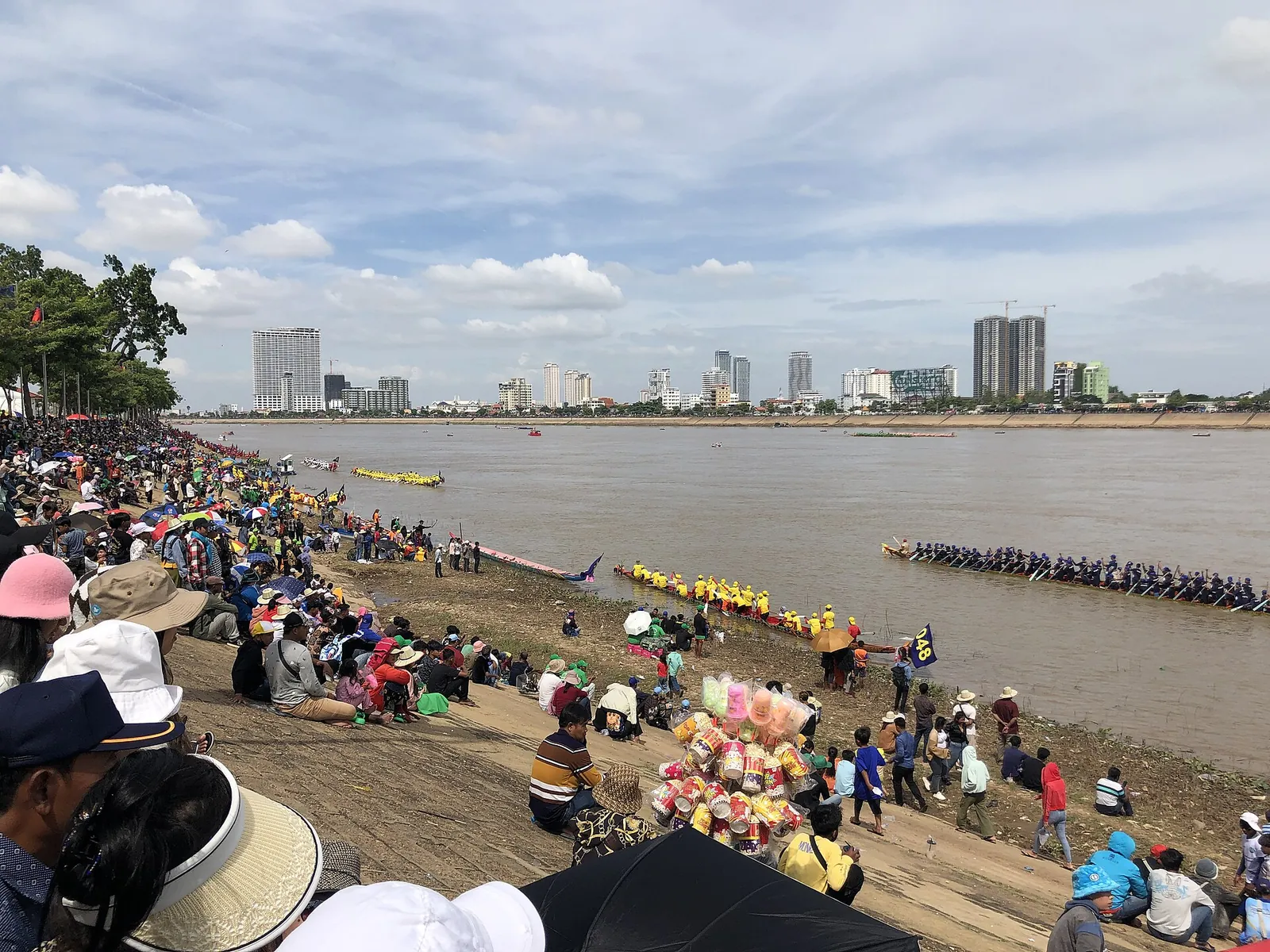 Menschenmengen am Flussufer beobachten Rennboote beim Wasserfest in Phnom Penh