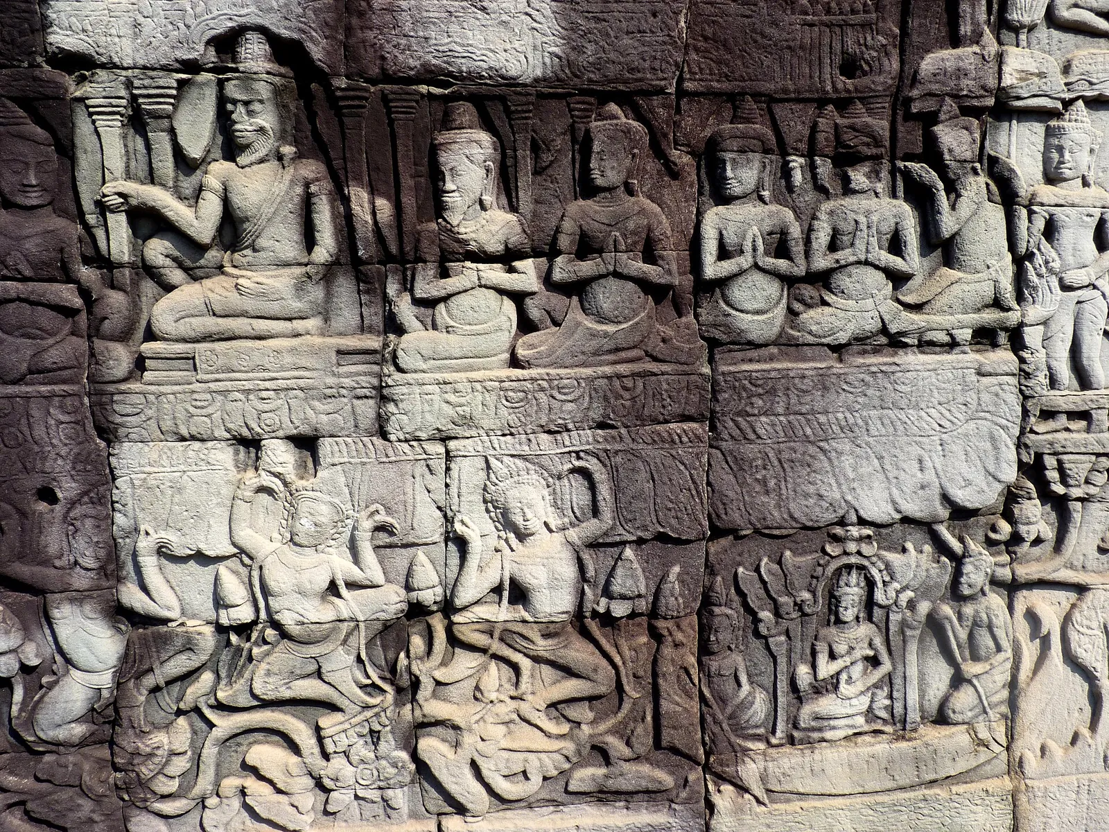 Filas de figuras sentadas y acompañantes en un bajorrelieve de Bayon