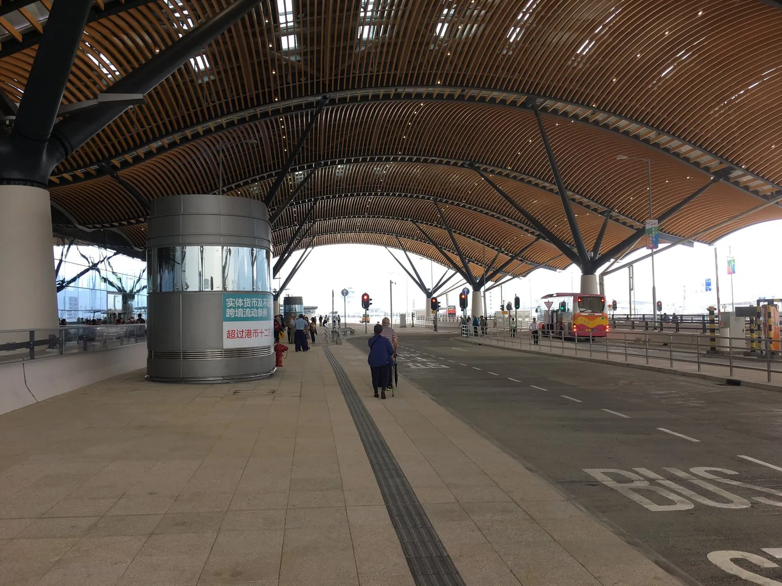 Autobusový nástupní prostor pod zakřivenou střechou hongkongského hraničního areálu HZMB