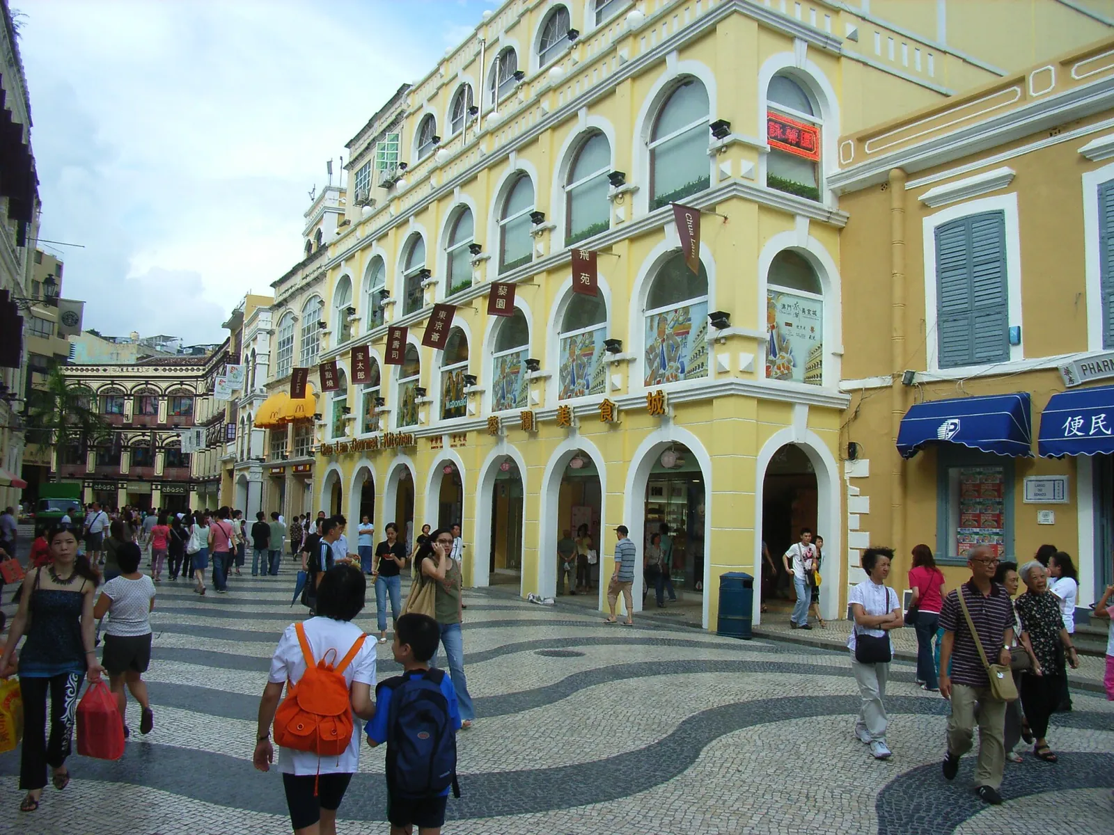 Žluté budovy s podloubím a vzorovaná dlažba náměstí Senado v Macau