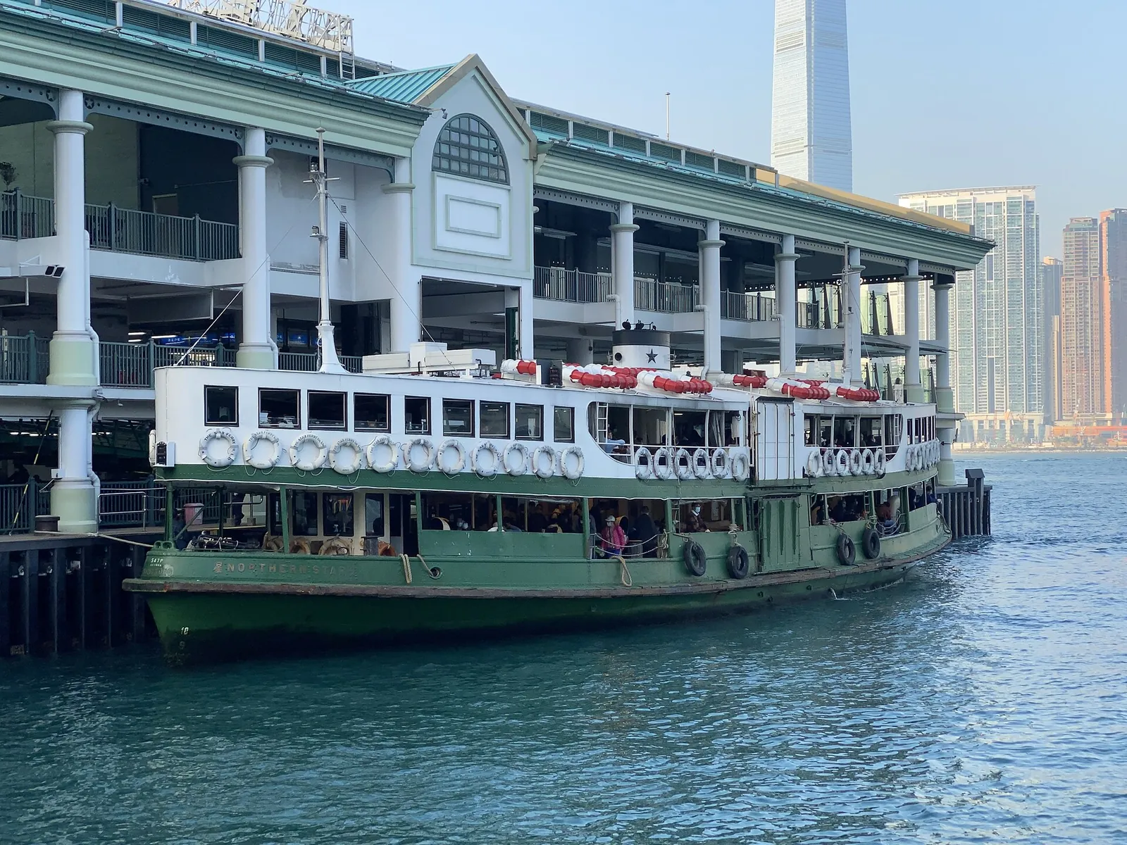 A green-and-white Star Ferry moored at its pier on Victoria Harbour