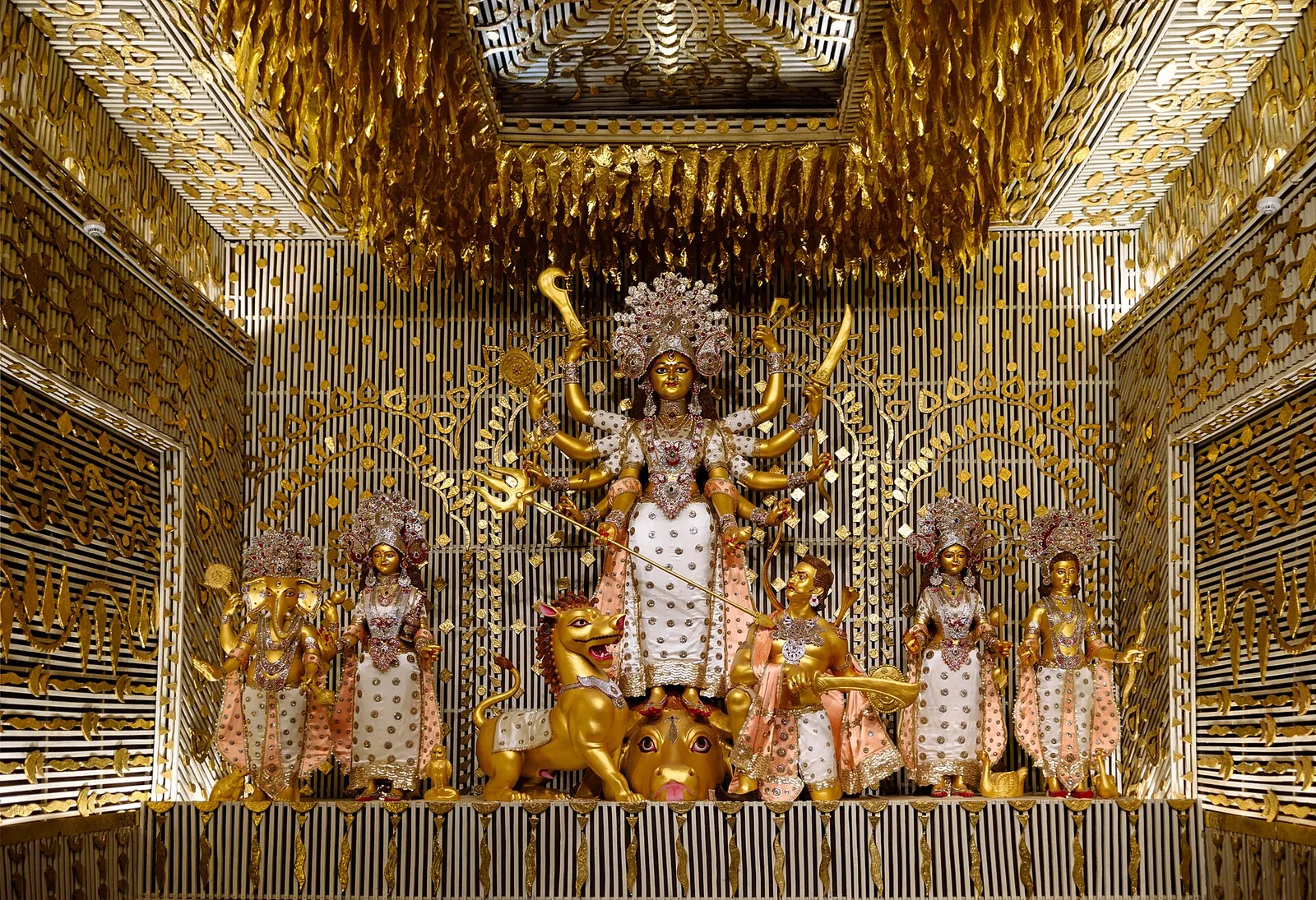 Una imagen dorada de la diosa Durga con otras deidades dentro de un pandal muy decorado en Calcuta