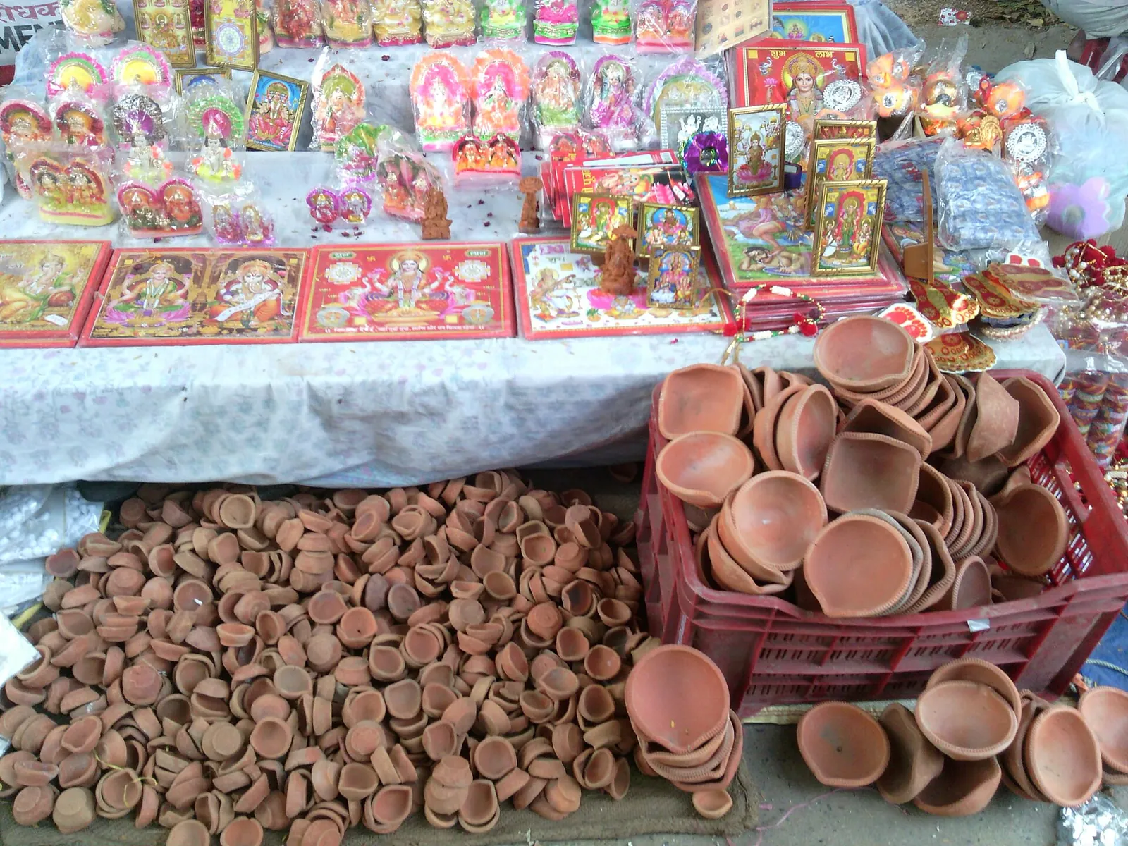 Lámparas de aceite de barro y adornos de colores de Diwali expuestos en un puesto de mercado