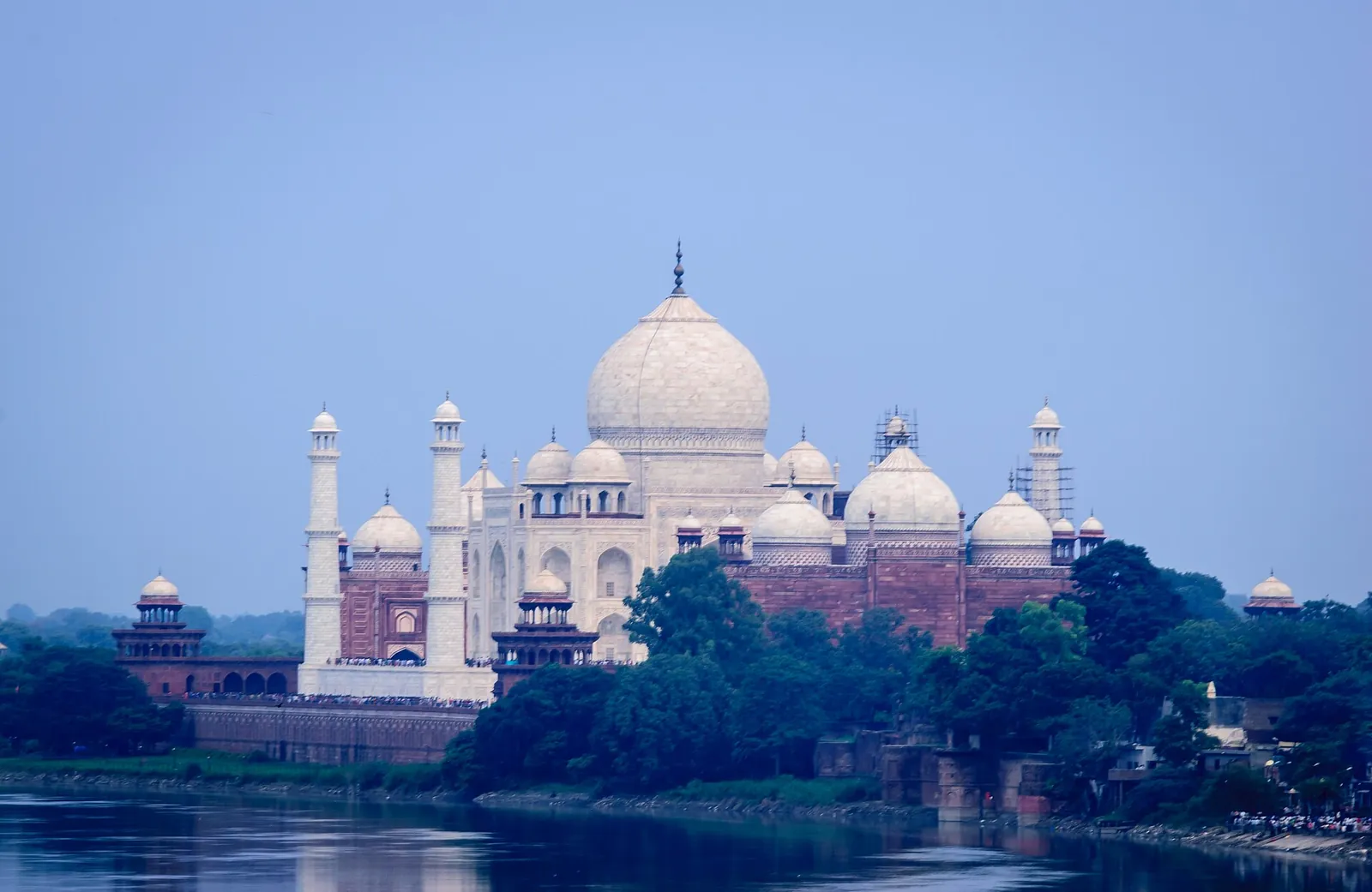 Bílý mramorový Taj Mahal a jeho minarety nad Jamunou, pohled z pevnosti Agra