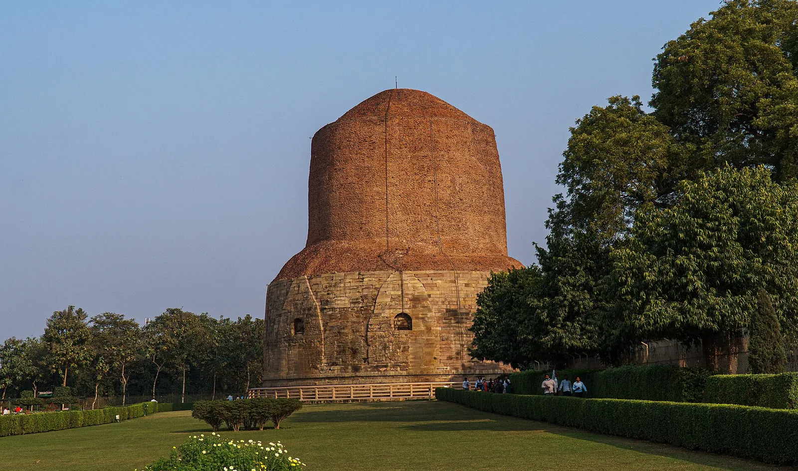 The brick Dhamekh Stupa rising above lawns at Sarnath