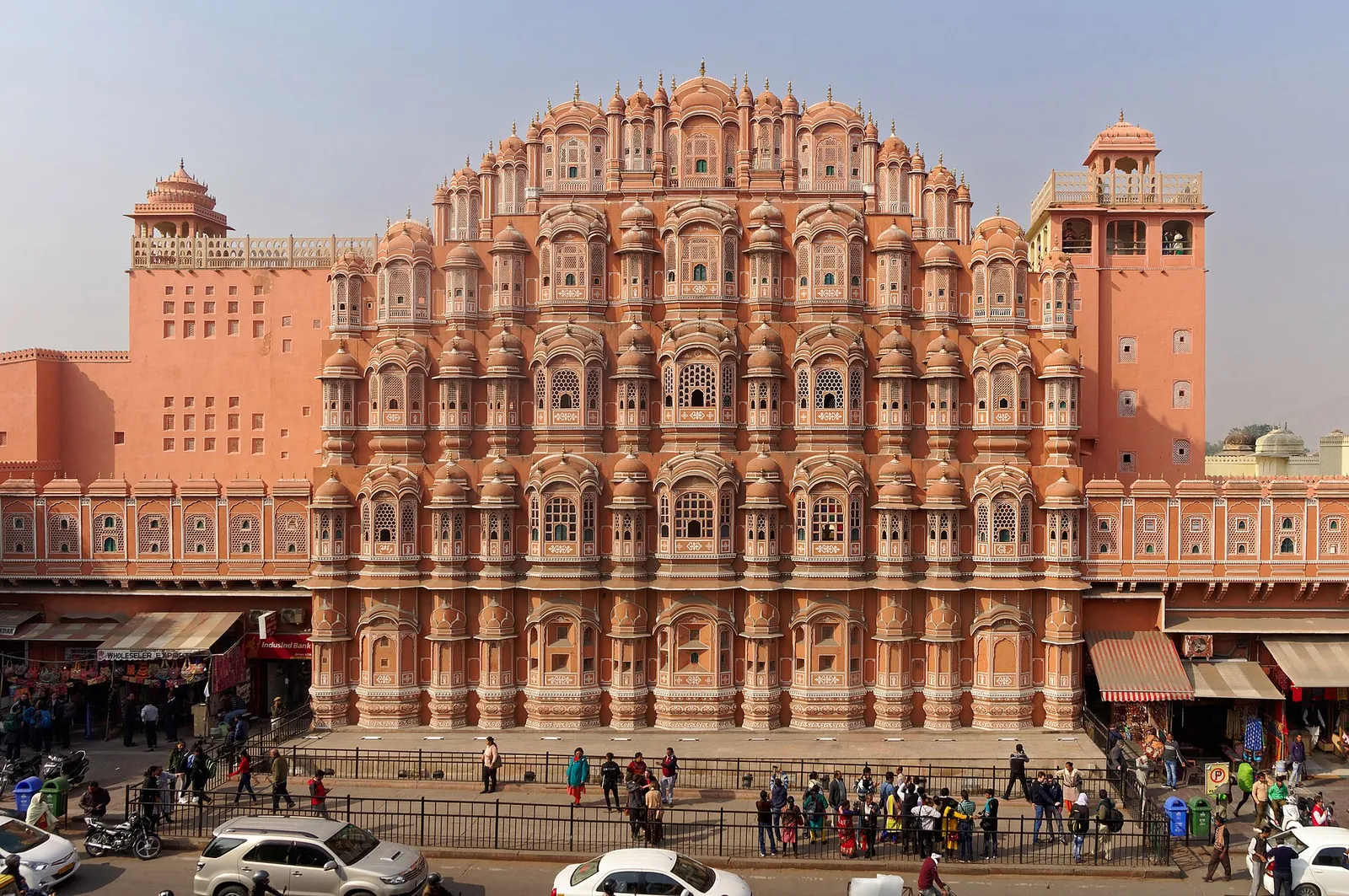 The pink honeycomb facade of the Hawa Mahal above a Jaipur street