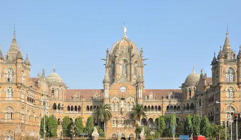 Nádraží Chhatrapati Shivaji Maharaj Terminus v Bombaji, gotická železniční stanice se středovou kopulí pod modrou oblohou