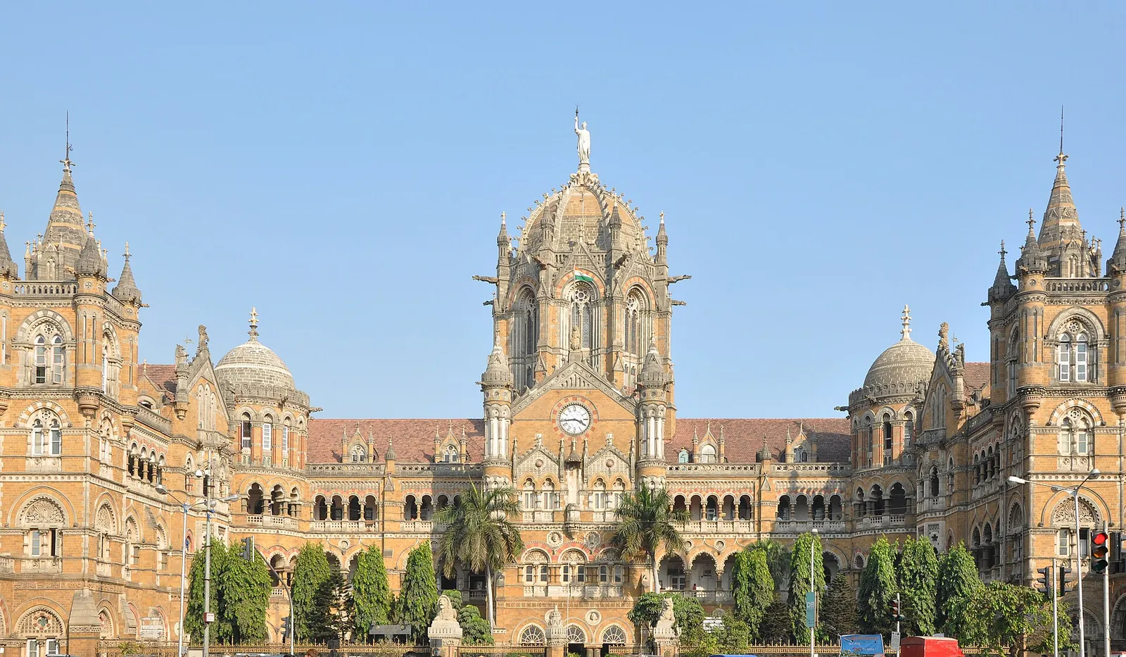 Gara Chhatrapati Shivaji Maharaj Terminus din Mumbai, o gară gotică cu cupolă centrală, sub un cer albastru