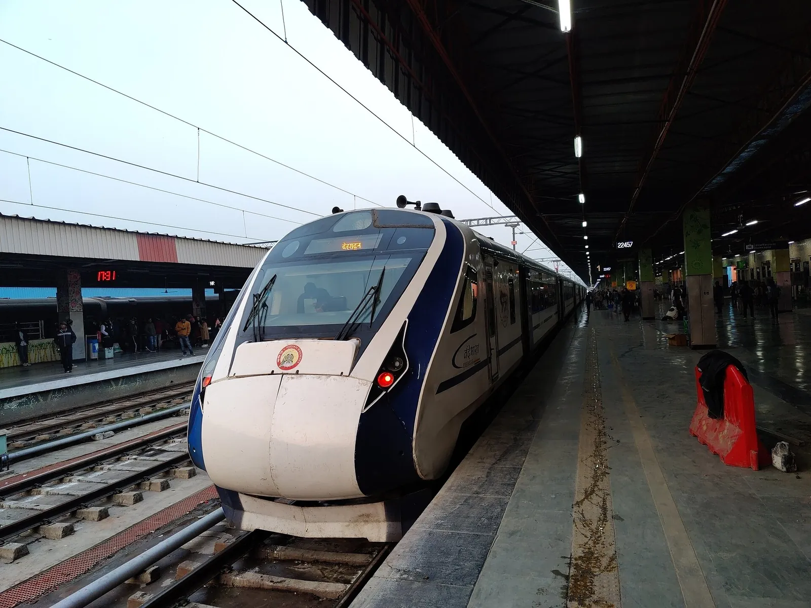 A white and blue Vande Bharat Express trainset waiting under the platform roof at Anand Vihar Terminal in Delhi