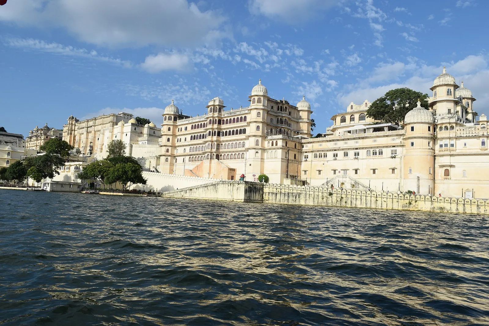 Městský palác v Udajpuru nad jezerem Pichola pod modrou oblohou