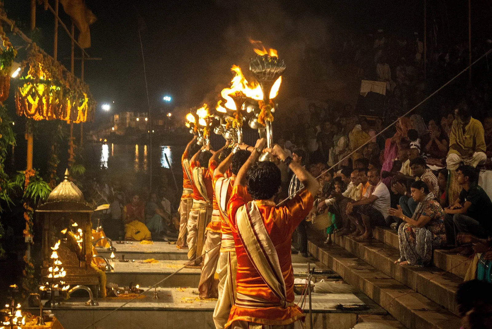 Preoți care săvârșesc Ganga aarti de seară cu lămpi la ghatul Dashashwamedh