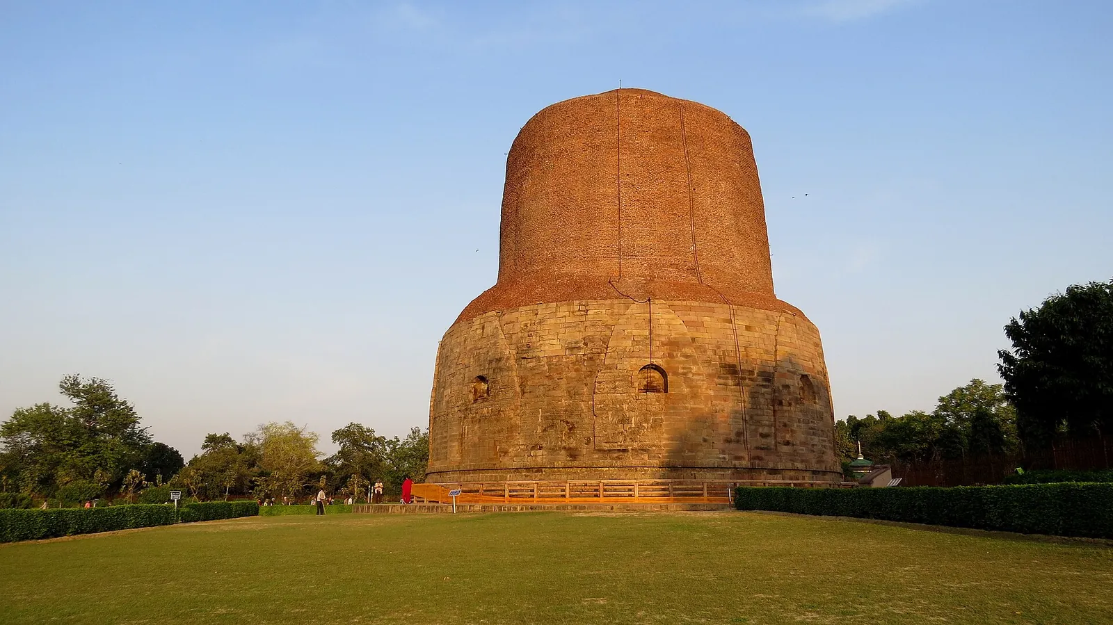 Stupa Dhamek din cărămidă și piatră de la Sarnath, pe un gazon