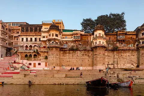 A Chausatti Ghat Varanasiban a kora reggeli napfényben, a lépcsői lábánál kikötött hajókkal