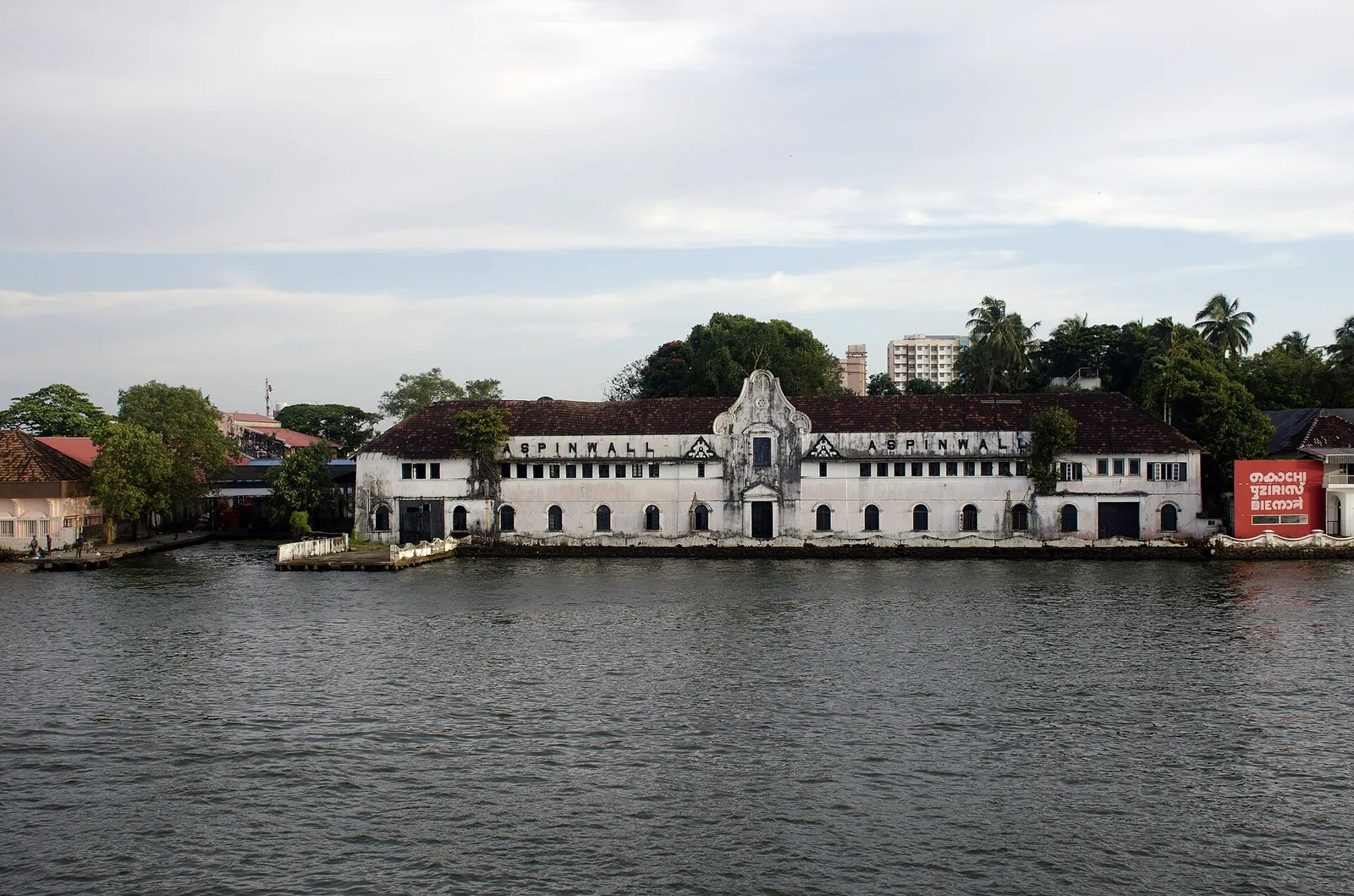 Aspinwall House, un largo edificio de la época colonial frente al agua en Fort Kochi, visto al otro lado del agua