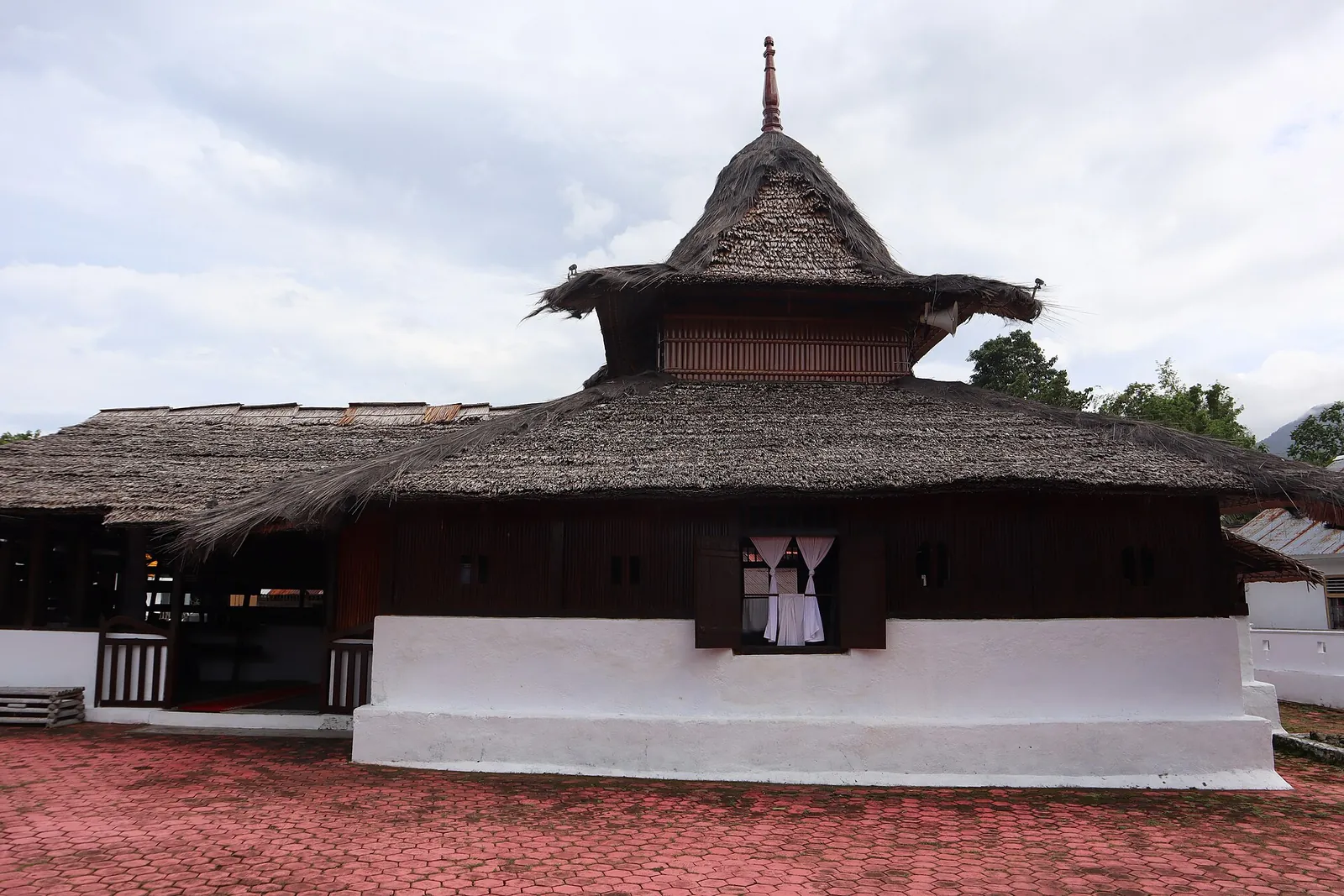 The tiered thatched roof and wooden walls of the Wapauwe Old Mosque at Kaitetu