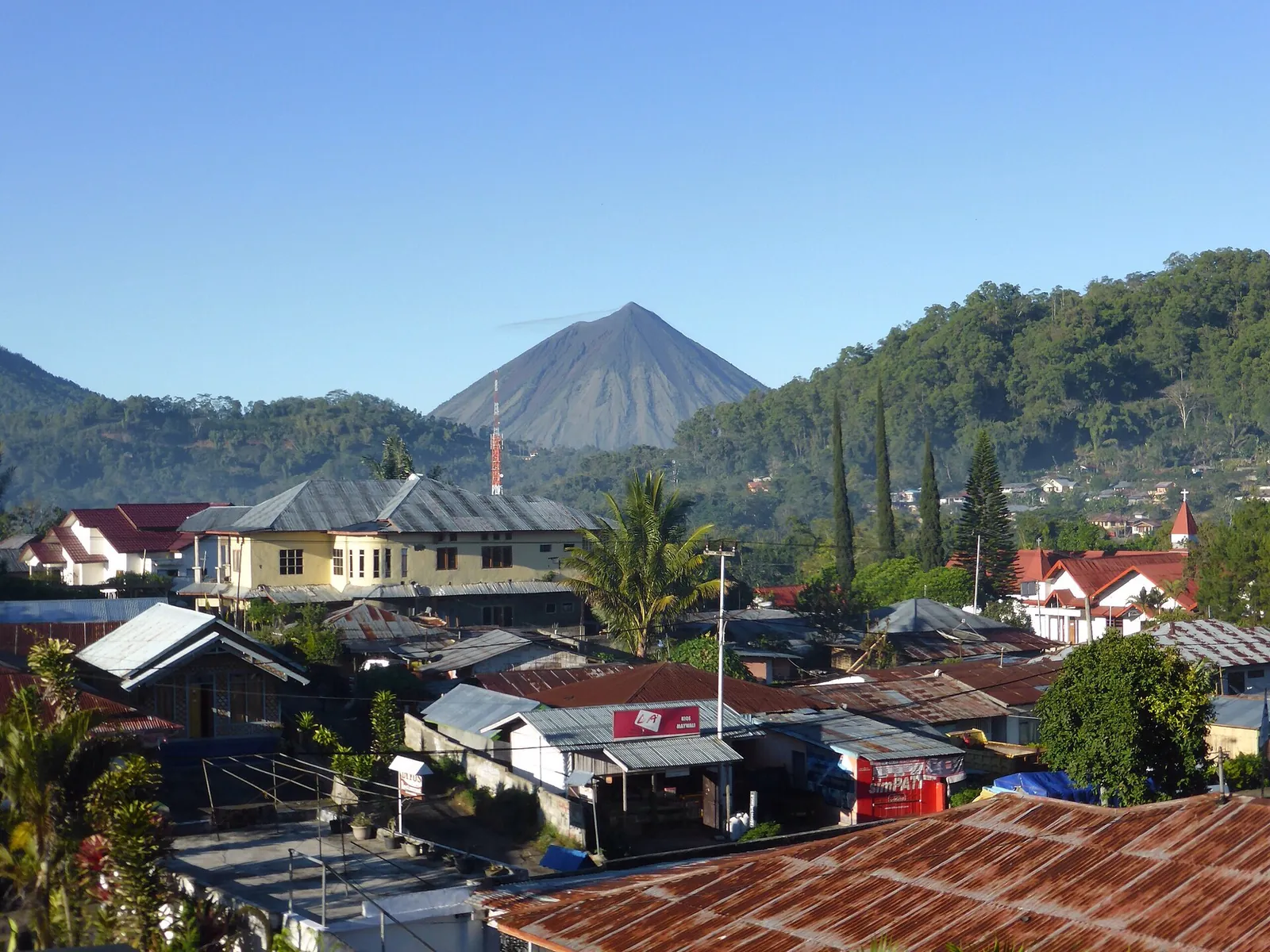 Bajawa town rooftops with the cone of Inerie volcano behind