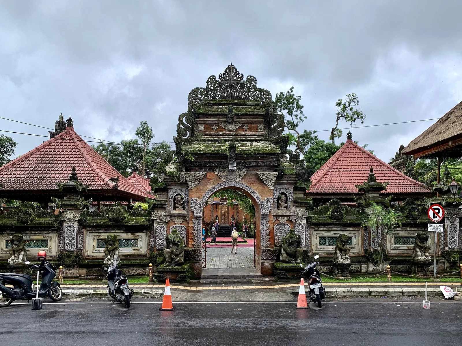 The carved stone gateway and red-tiled pavilions of Ubud Palace seen from the street