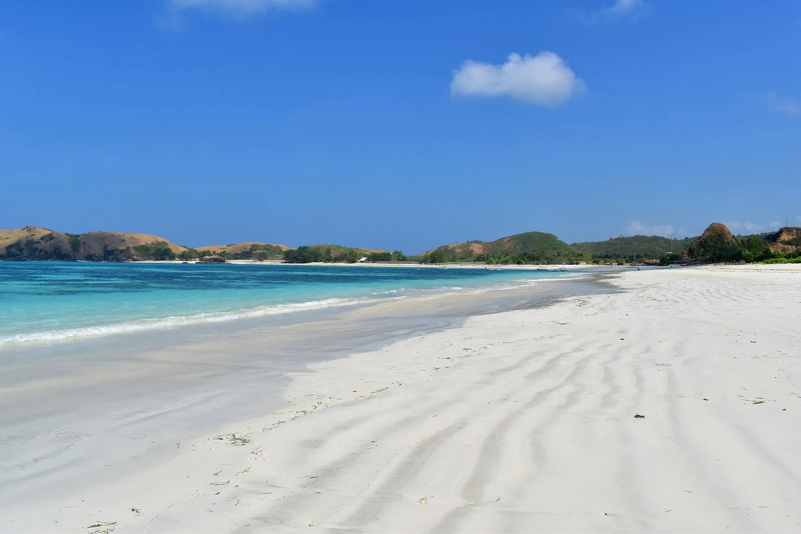 Wide white-sand beach at Tanjung Aan on Lombok's south coast under a blue sky