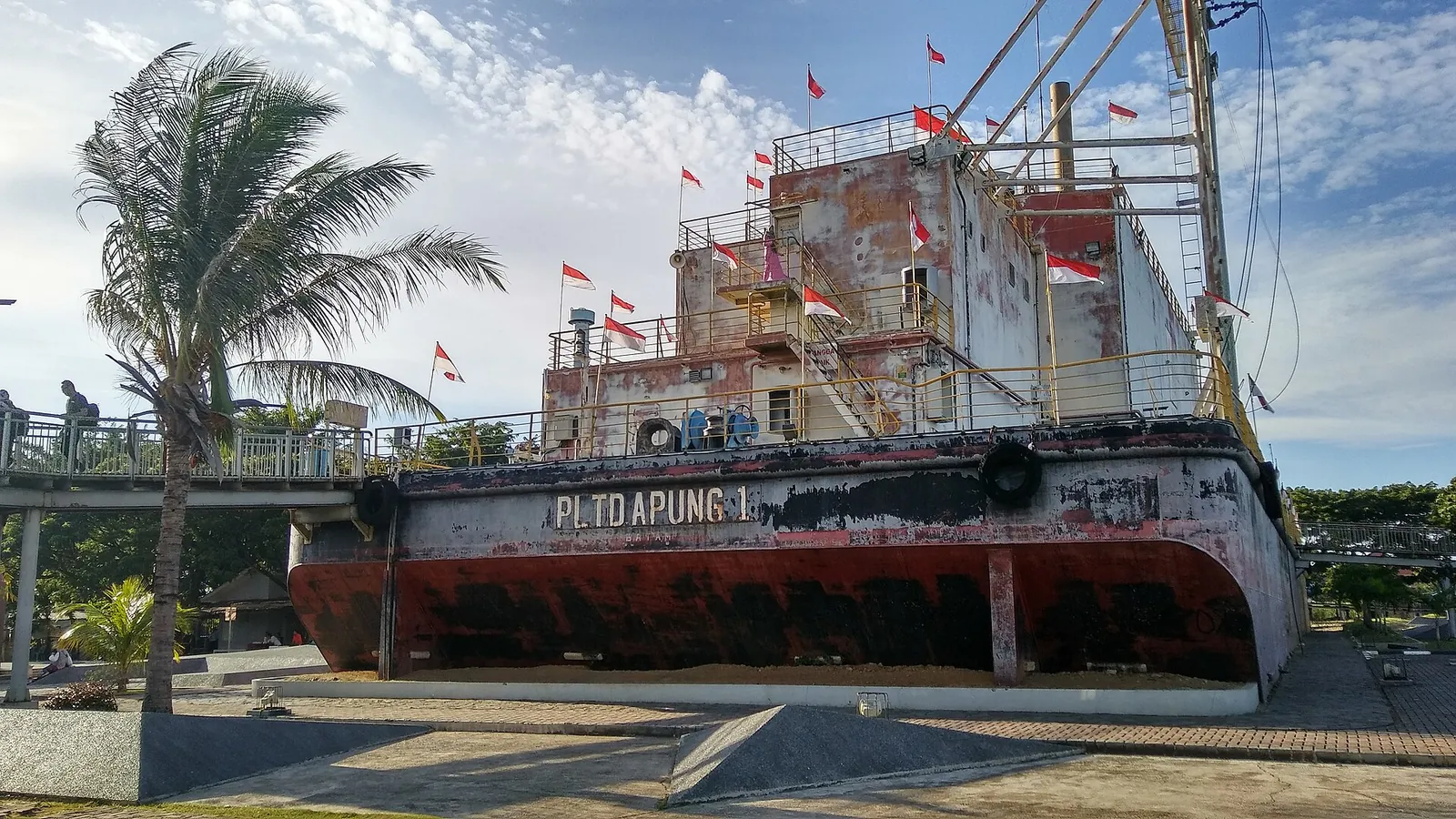 The PLTD Apung generator ship sitting on land among palm trees in Banda Aceh