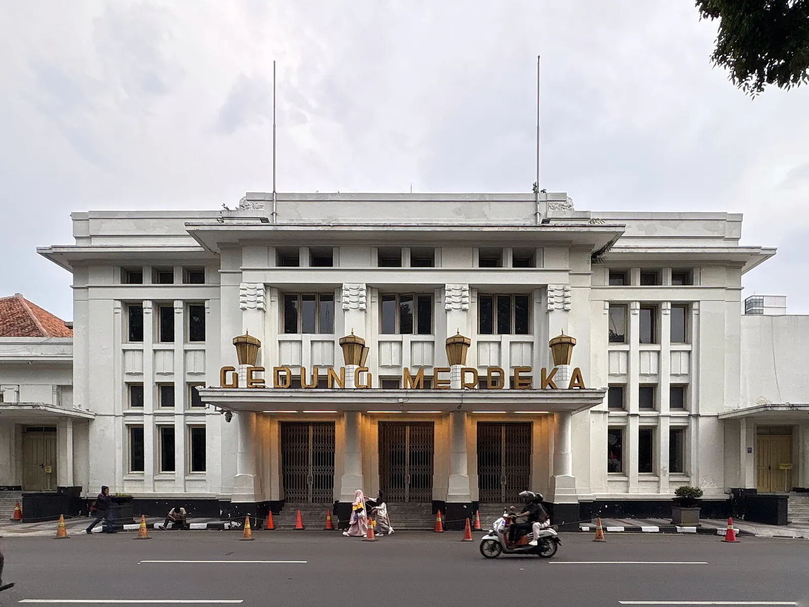 The white facade of Gedung Merdeka on Jalan Asia Afrika in Bandung, with its name in gold letters above the entrance