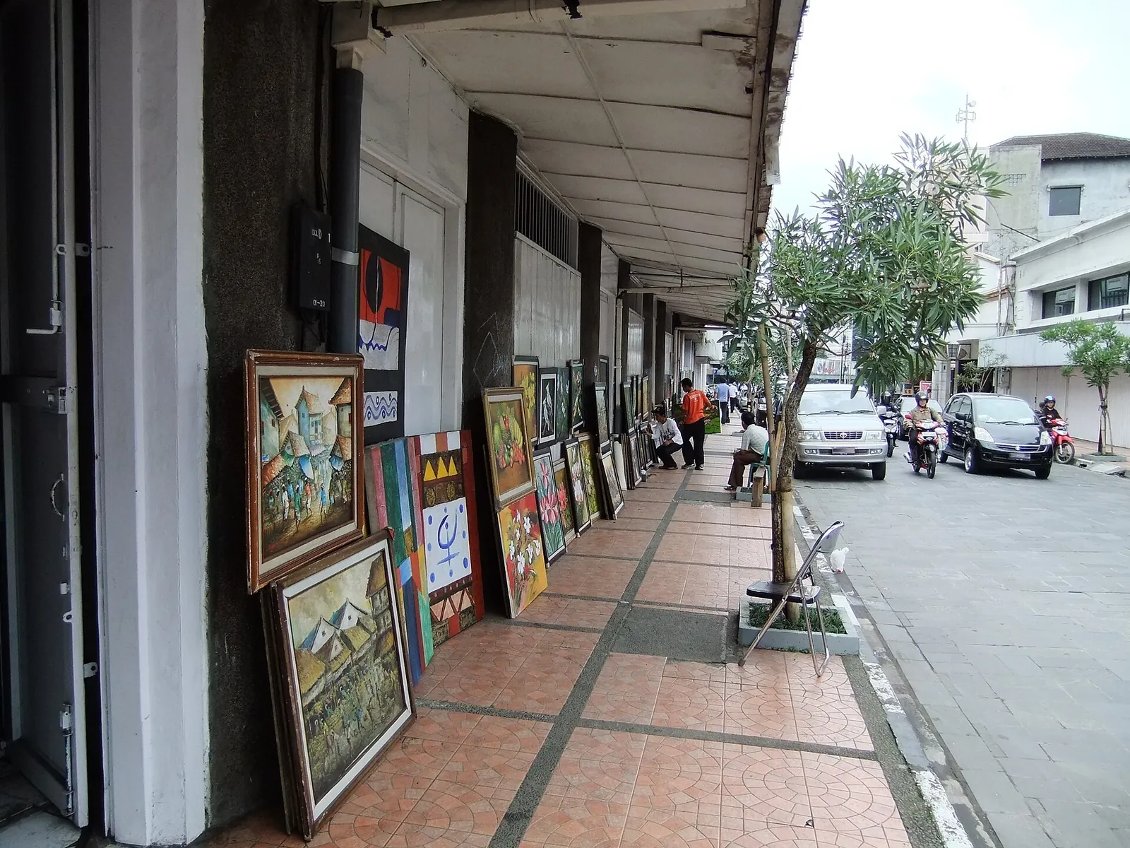 Paintings propped against a shopfront under the arcade of Jalan Braga in central Bandung