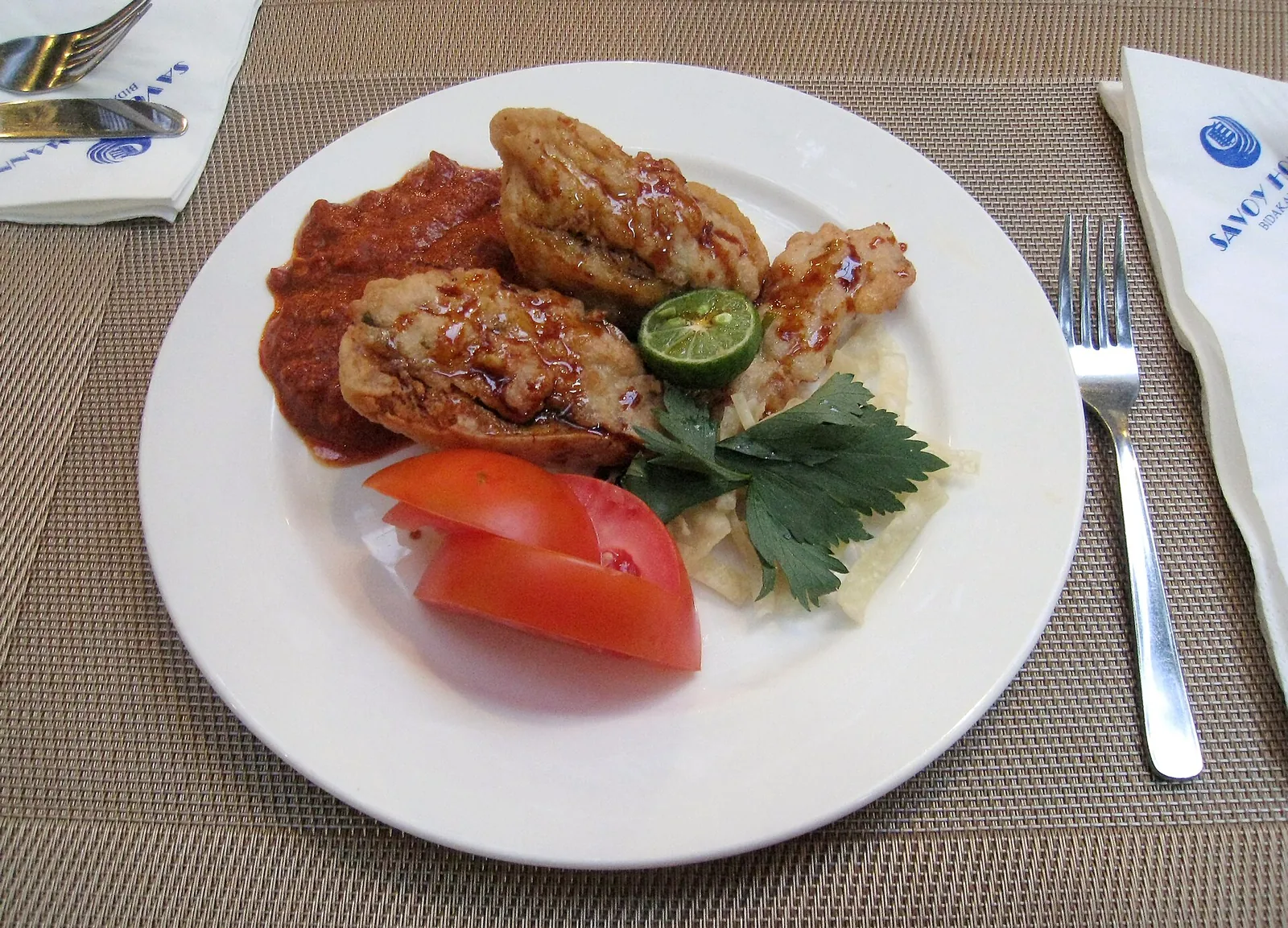 A plate of batagor, fried fish-and-tofu dumplings with peanut sauce, lime and tomato, at the Savoy Homann hotel in Bandung