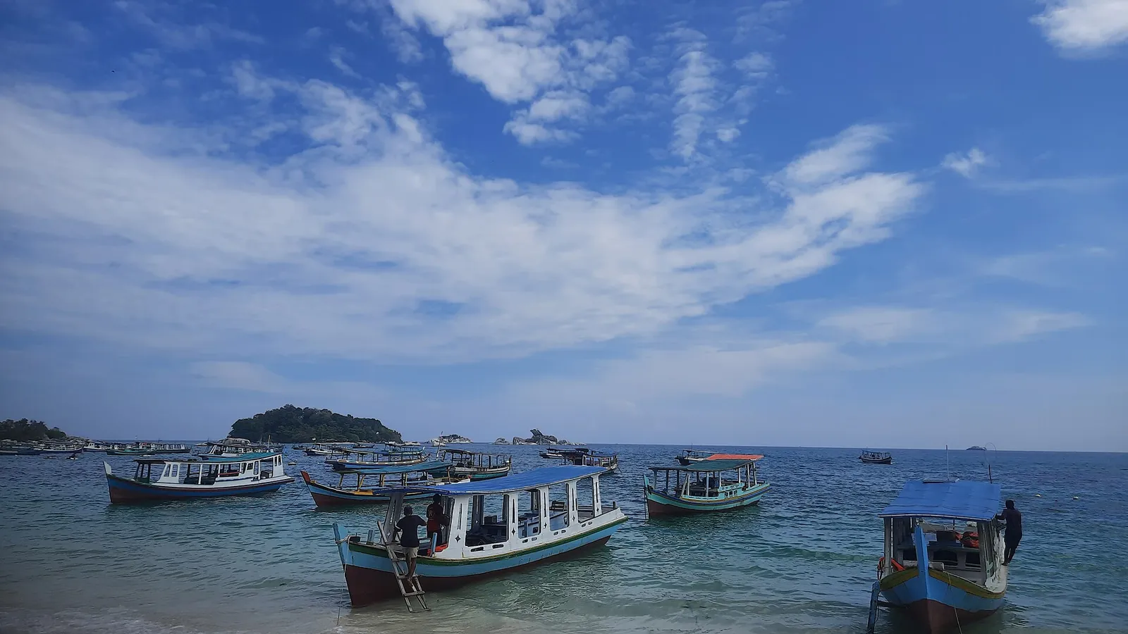 Wooden island-hopping boats moored in the shallow water off Tanjung Kelayang Beach, Belitung