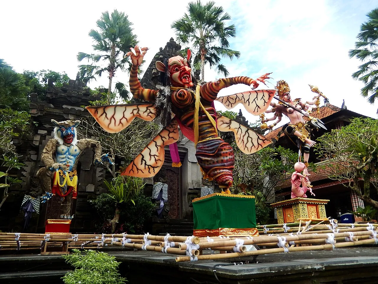 Large painted ogoh-ogoh effigies on a bamboo platform in front of the Puri Lukisan Museum in Ubud