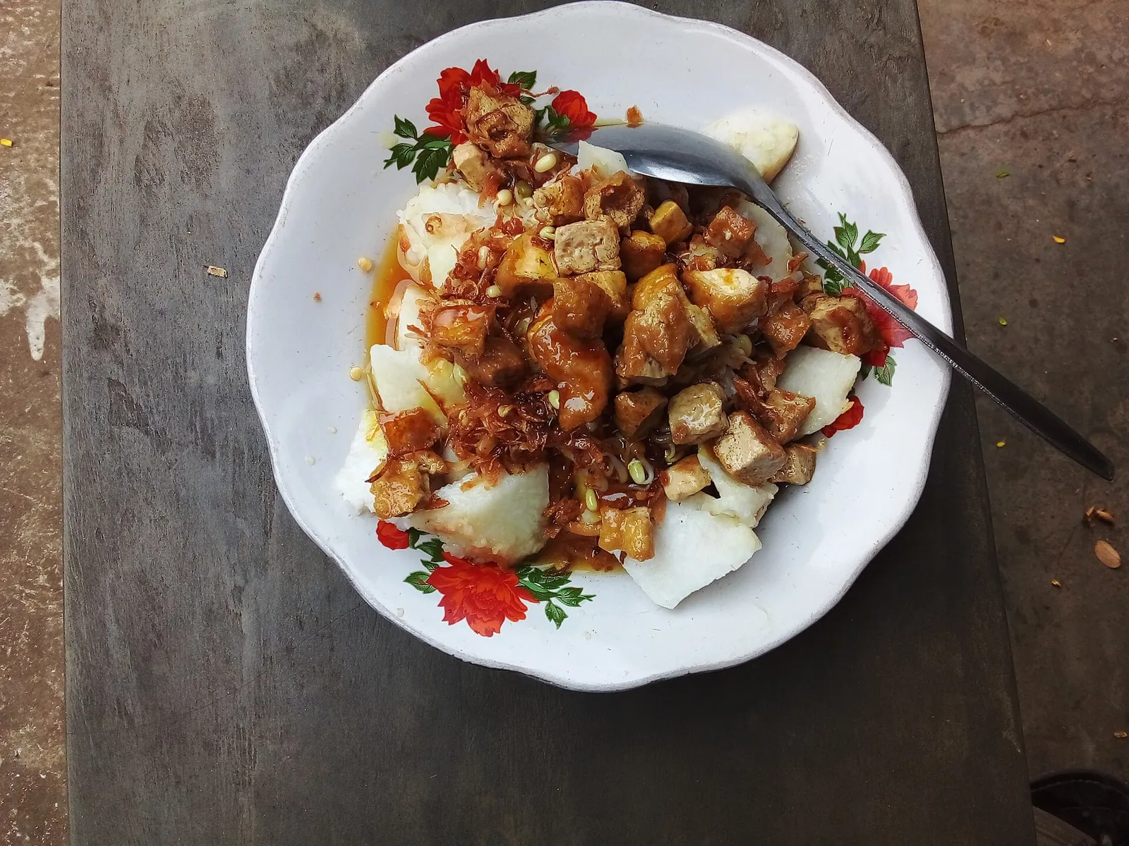 Plate of kupat tahu with rice cake, fried tofu and peanut sauce