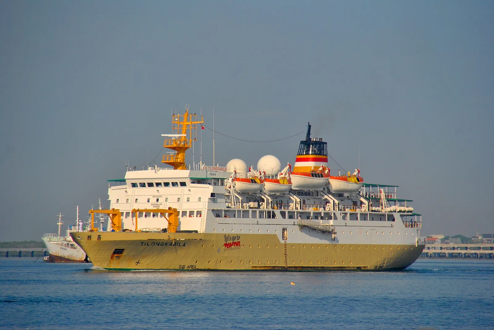The white and yellow Pelni passenger ship KM Tilong Kabila sailing out of Benoa harbour, Bali