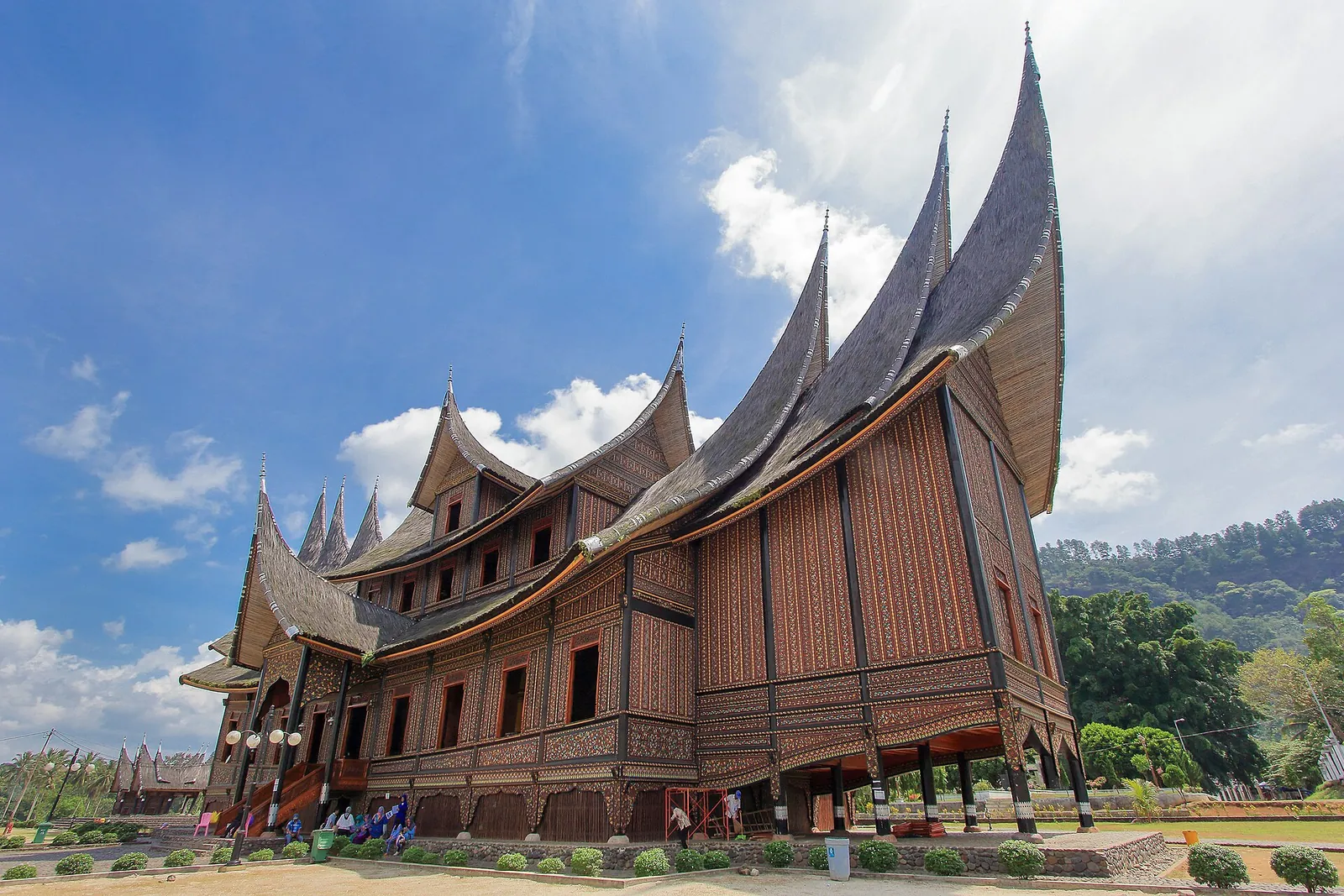 Istano Basa Pagaruyung, a wooden palace with many sweeping horn-shaped roof spires, under a blue sky