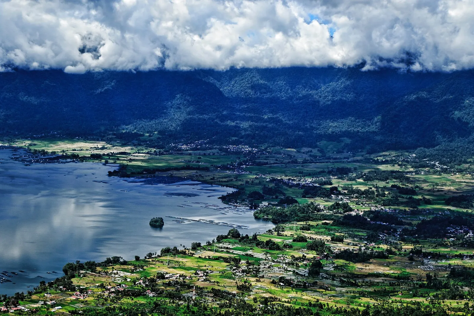 Lake Maninjau seen from high on the crater rim, with villages and rice fields along the shore