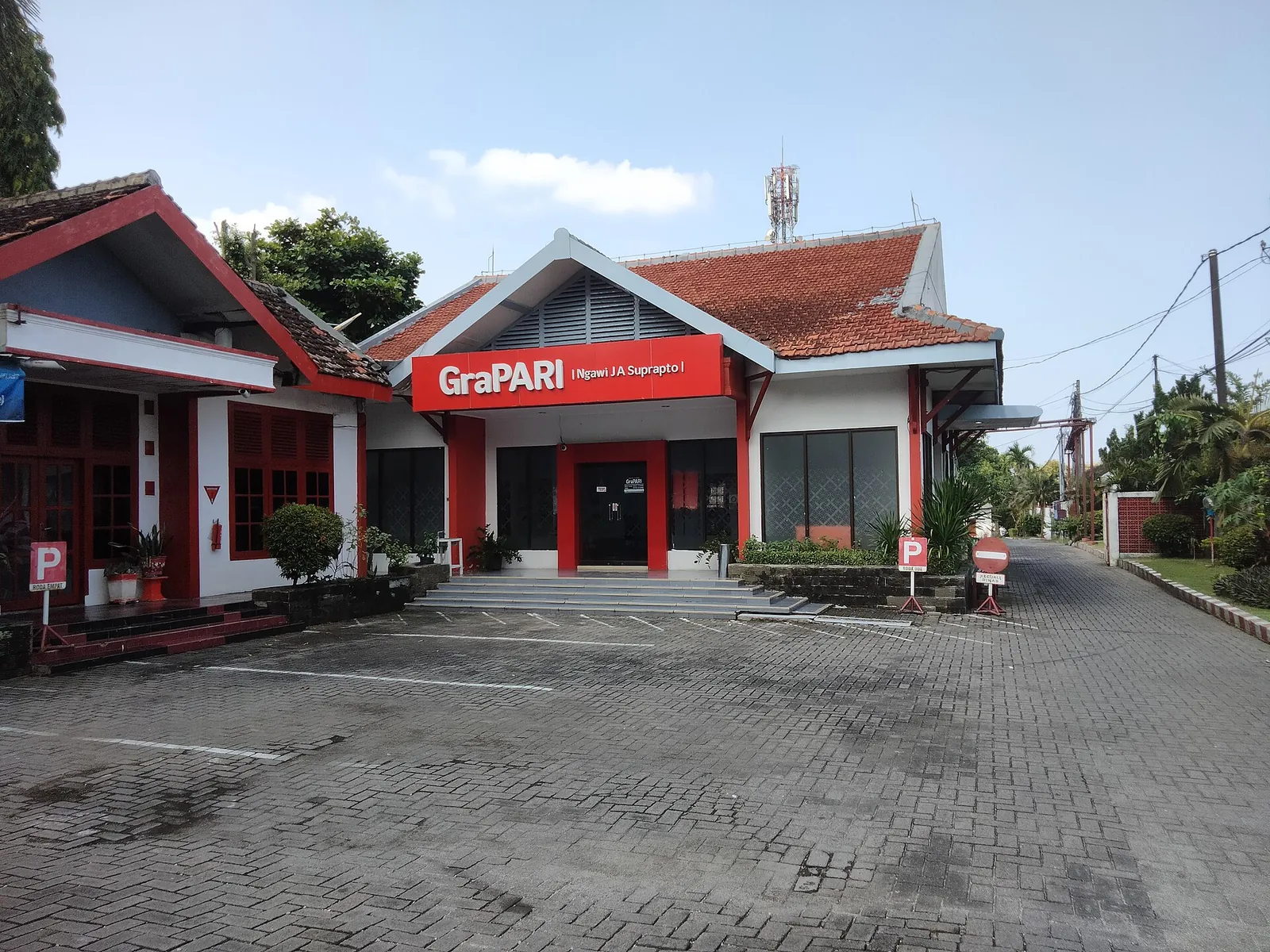 Red-roofed GraPARI Telkomsel customer service office with its car park in Ngawi, East Java