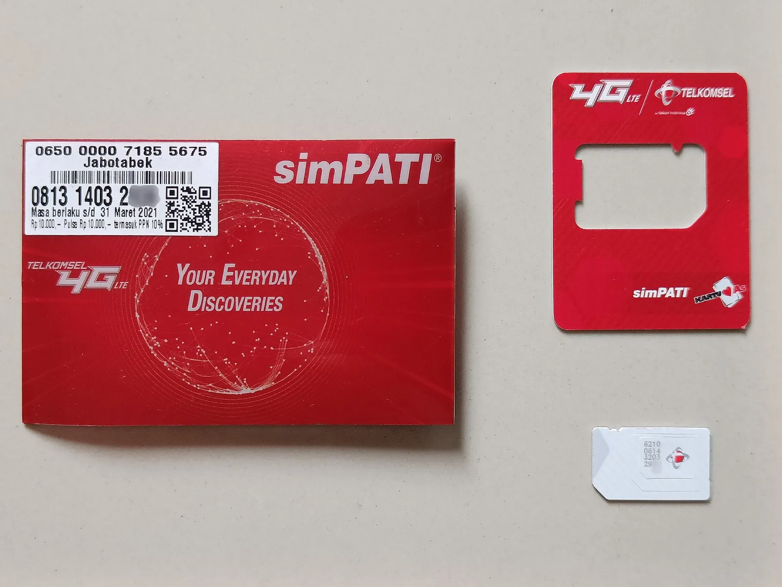 Telkomsel simPATI starter pack opened to show the red card, the SIM card holder and the SIM chip