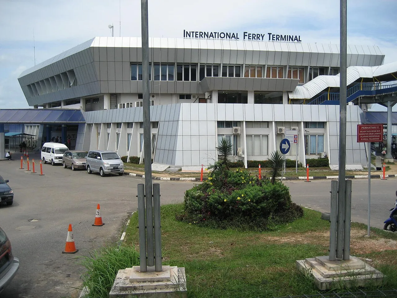 White International Ferry Terminal building at Batam Centre with parked cars in front