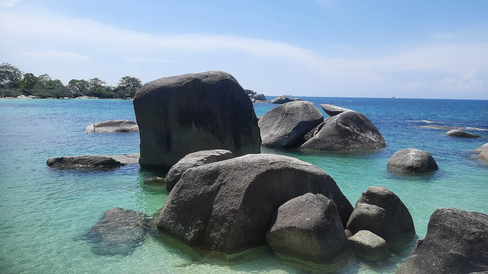 Large granite boulders in clear green water at Tanjung Tinggi beach, Belitung