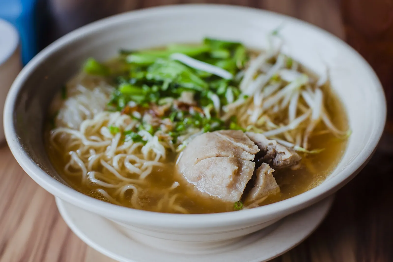 A bowl of Indonesian bakso meatball soup with noodles, bean sprouts and green onion