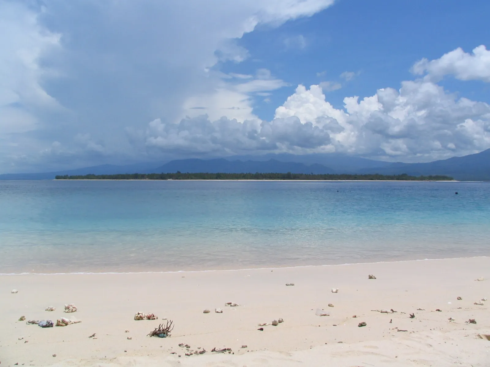 Gili Air seen across shallow turquoise water from a beach on Gili Meno