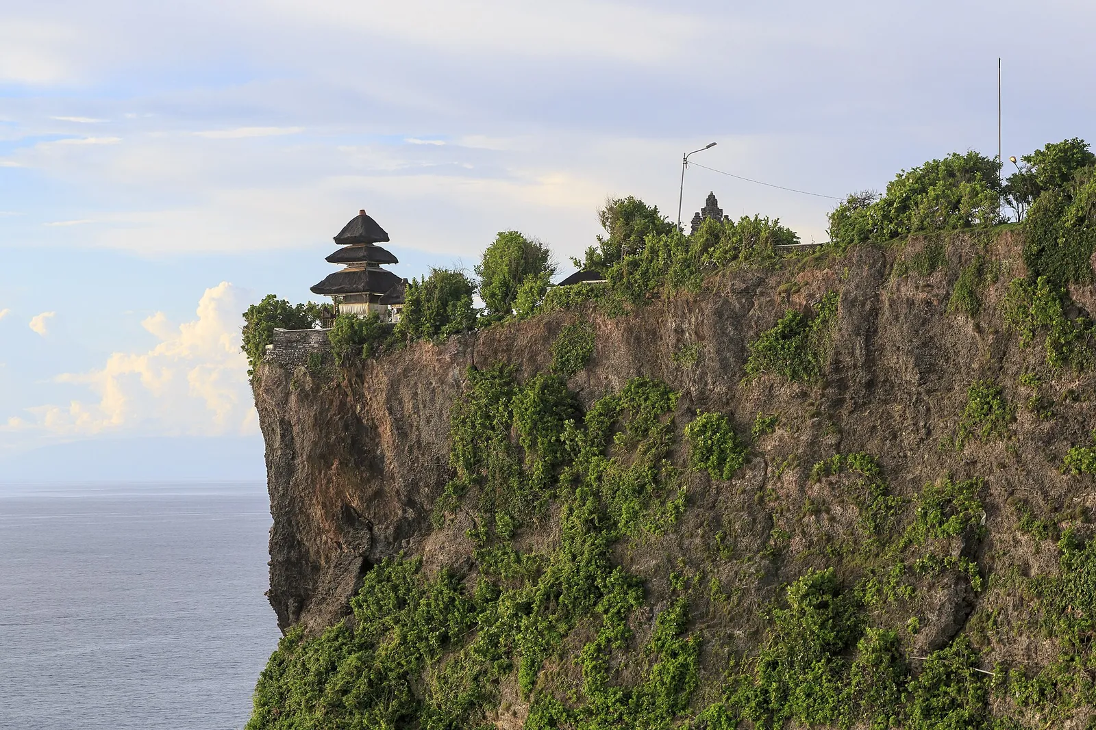 A shrine of Pura Luhur Uluwatu perched on top of a sheer cliff above the Indian Ocean