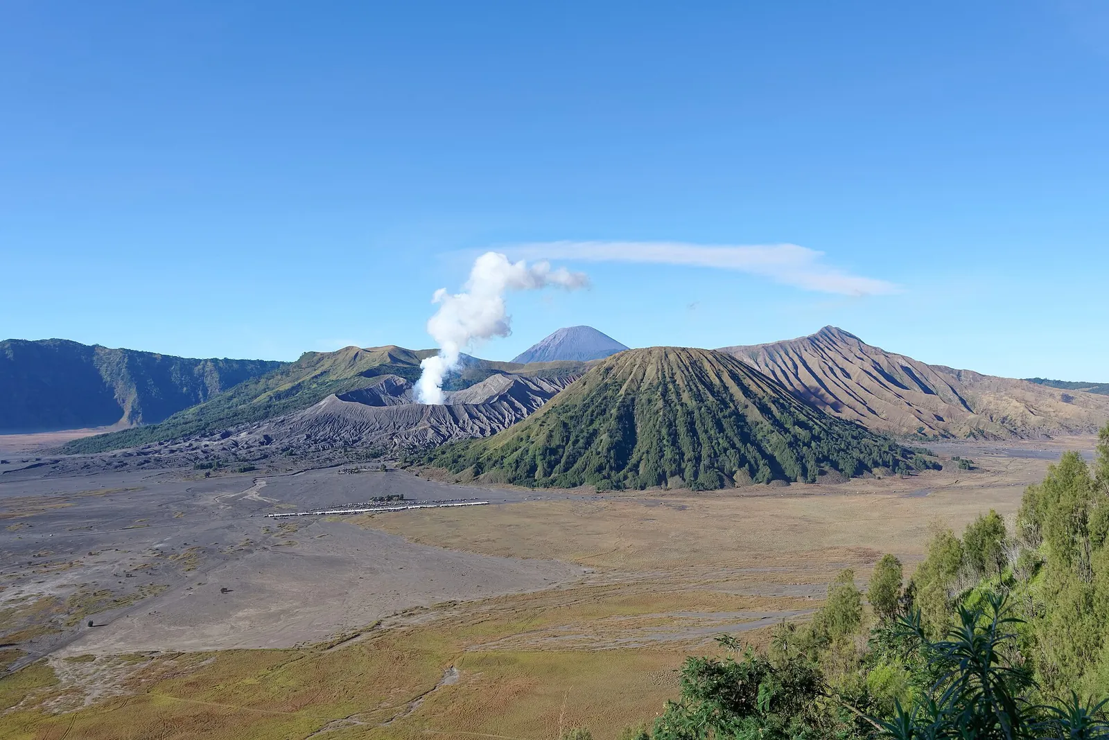 The Tengger caldera with a smoking Mount Bromo, Batok and Semeru behind, seen from the rim