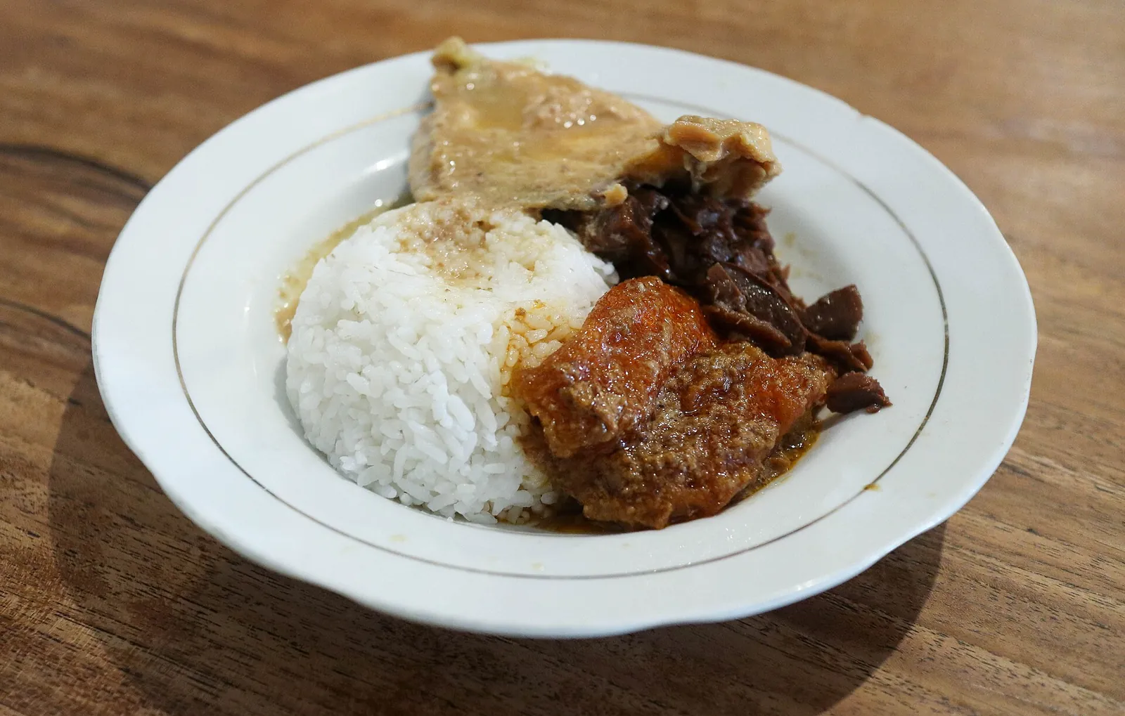 A plate of gudeg in Yogyakarta: white rice with brown jackfruit stew and side dishes