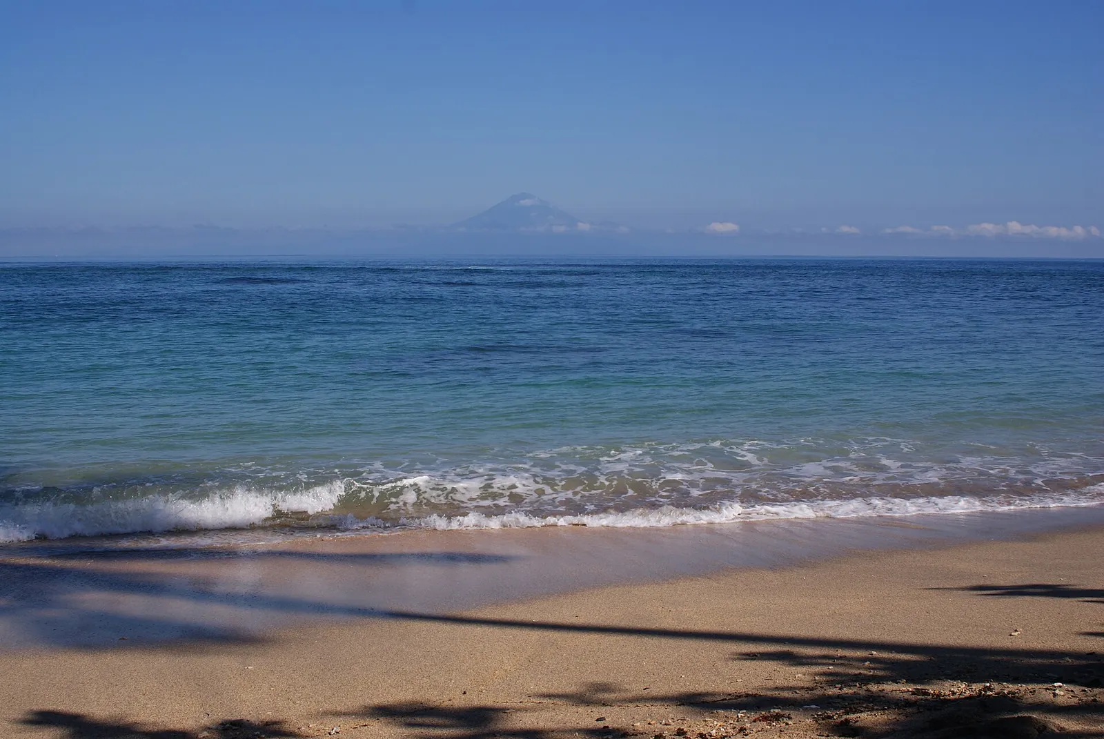 Senggigi Beach on Lombok's west coast, with Bali's Mount Agung on the horizon across the Lombok Strait