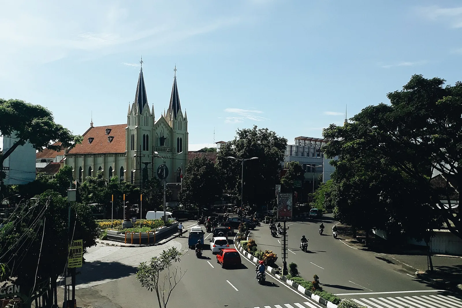 Kayutangan Street in central Malang with traffic and a twin-spired church in the background