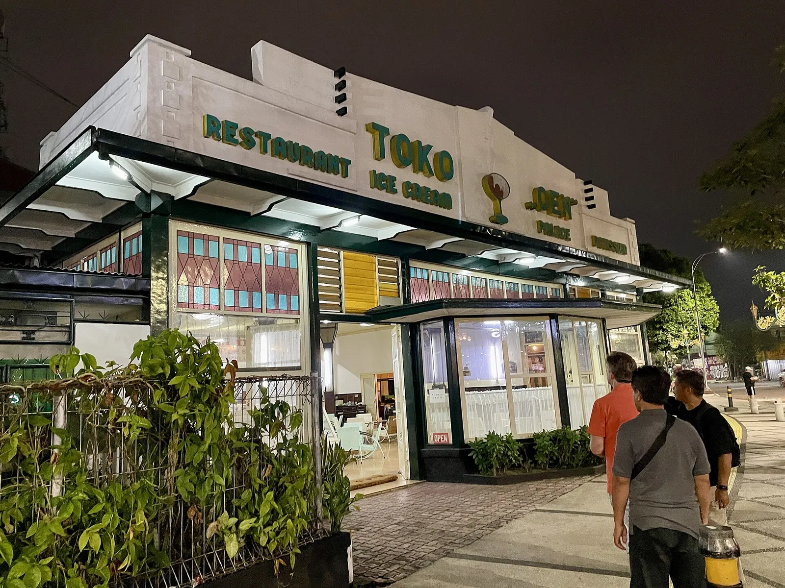The lit front of Toko Oen restaurant on a corner in Kayutangan, Malang, at night