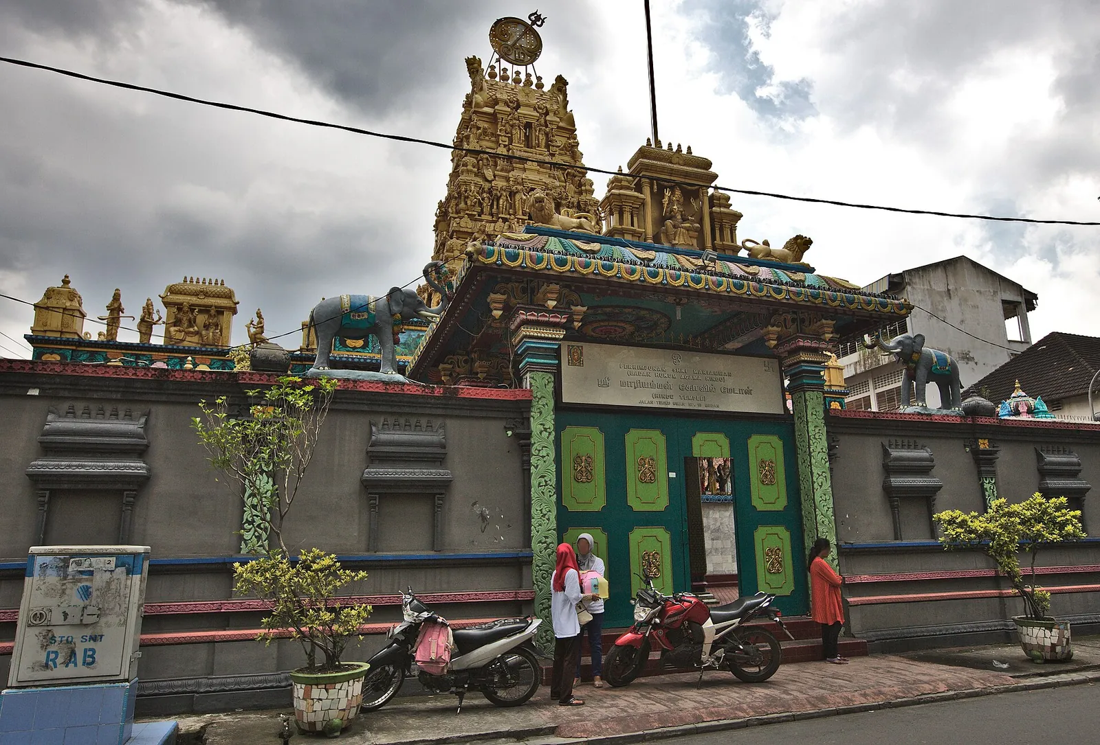 Ornate Dravidian-style gate tower and green doors of the Shri Mariamman Hindu temple on a Medan street