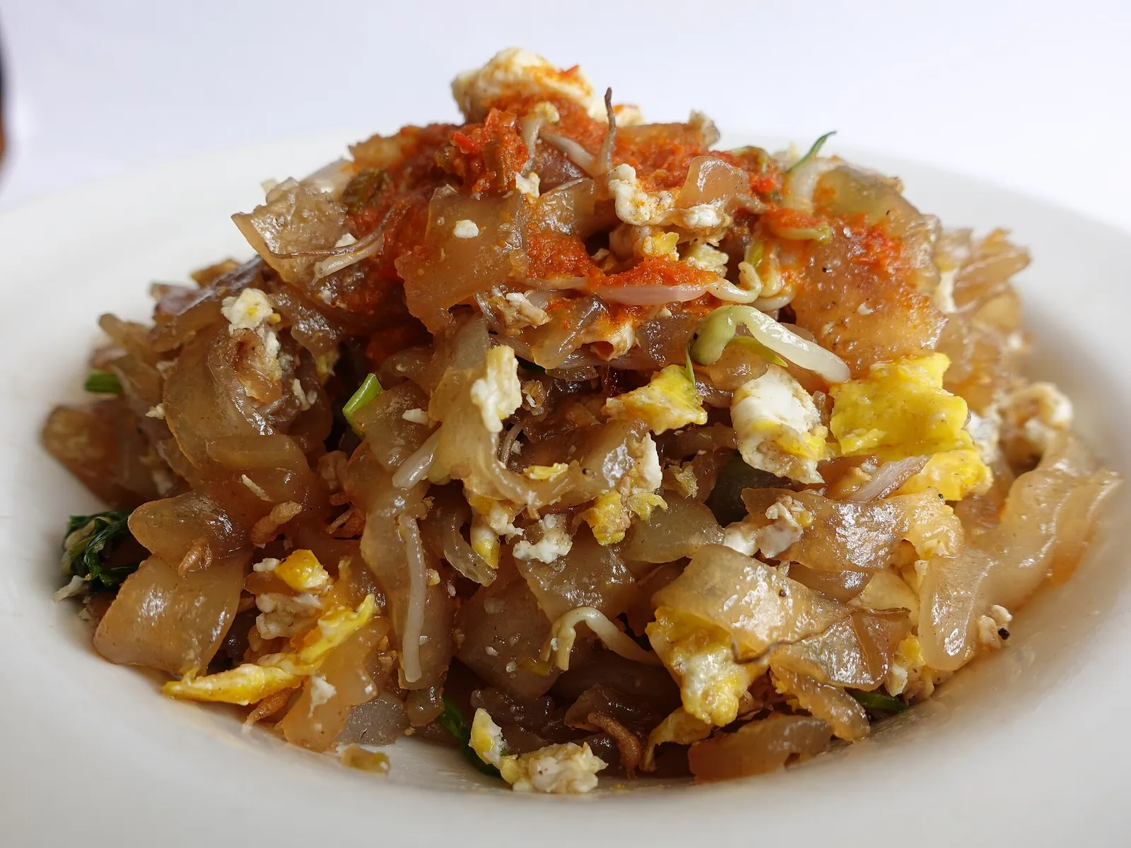 A plate of mi balap, wok-fried flat noodles with egg and vegetables