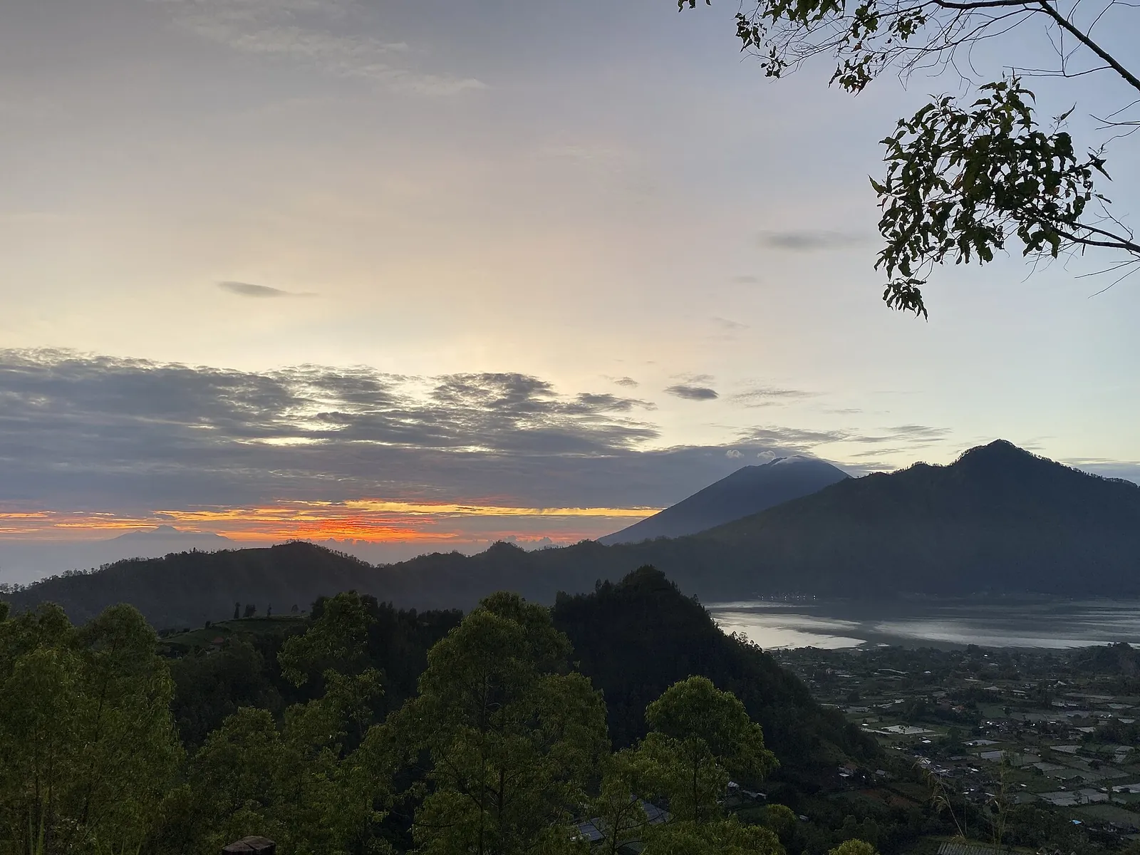 Dawn sky over the dark silhouettes of the Batur caldera with the lake below