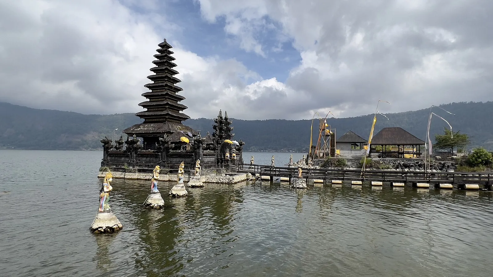 Tiered shrine of Pura Segara Ulun Danu Batur standing in Lake Batur under a cloudy sky